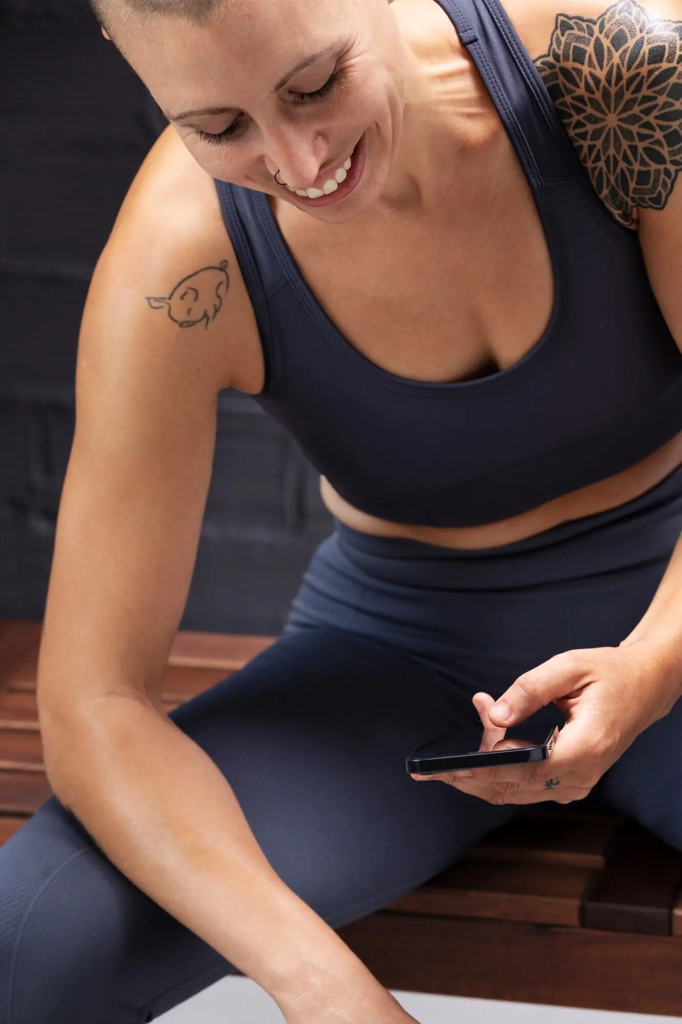 Primer plano de una mujer sonriente sosteniendo un teléfono.